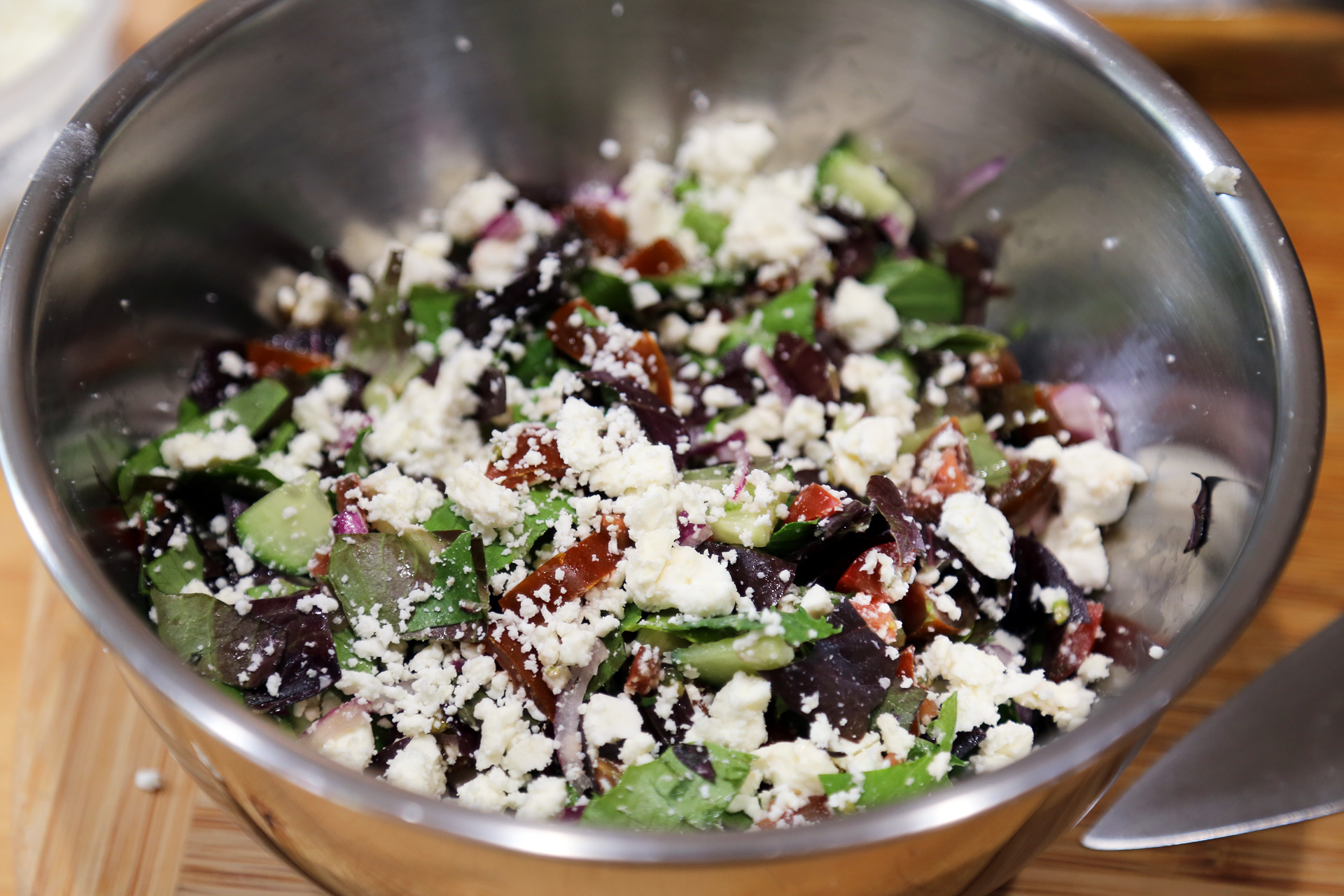 Toss together the lettuce, feta, cherry tomatoes, cucumber, and red onion.