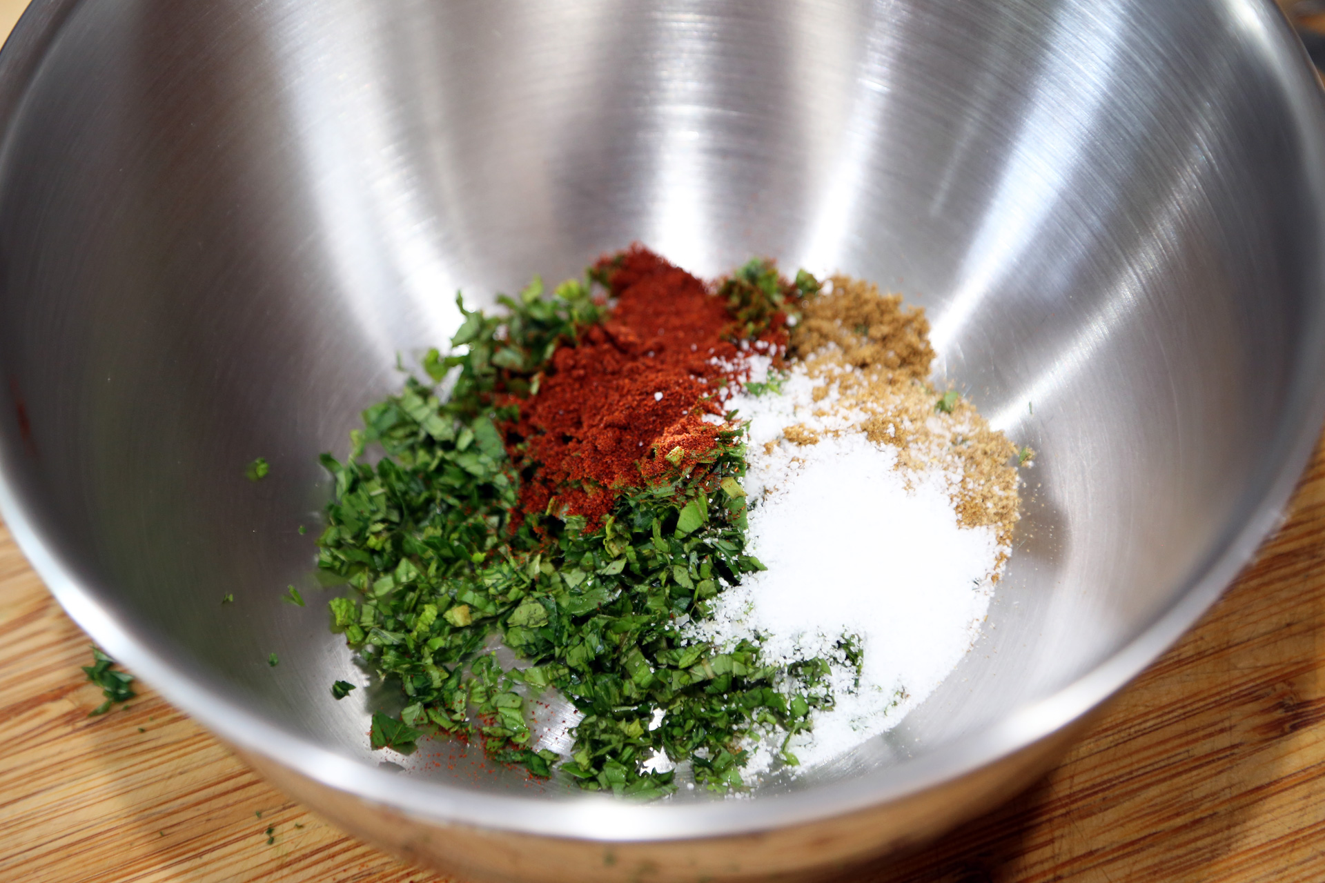 In a bowl, stir together the herbs, spices, salt, and oil.