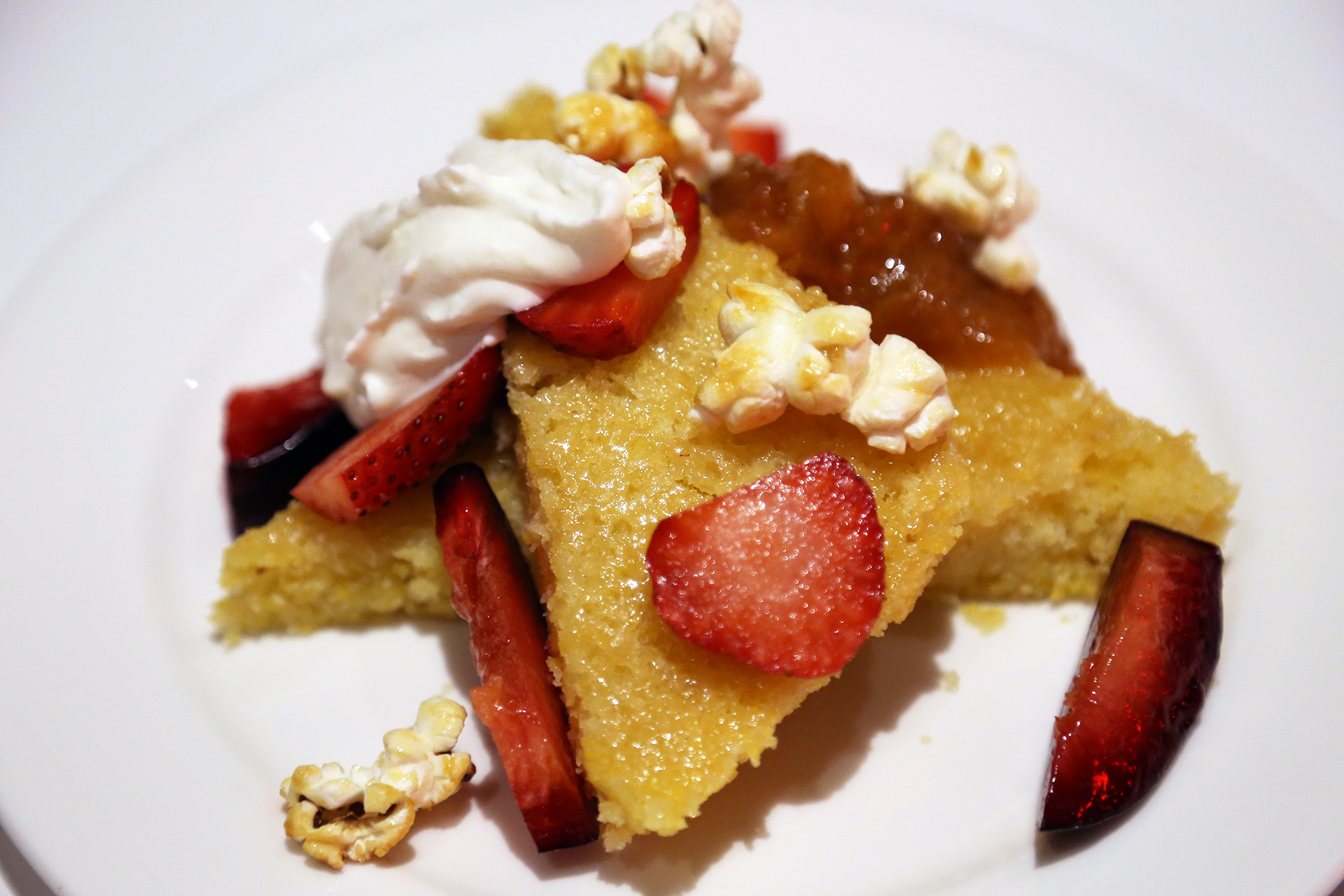 Polenta cake topped with ricotta cream, summer fruit, and a surprising and wonderful garnish of kettle corn.