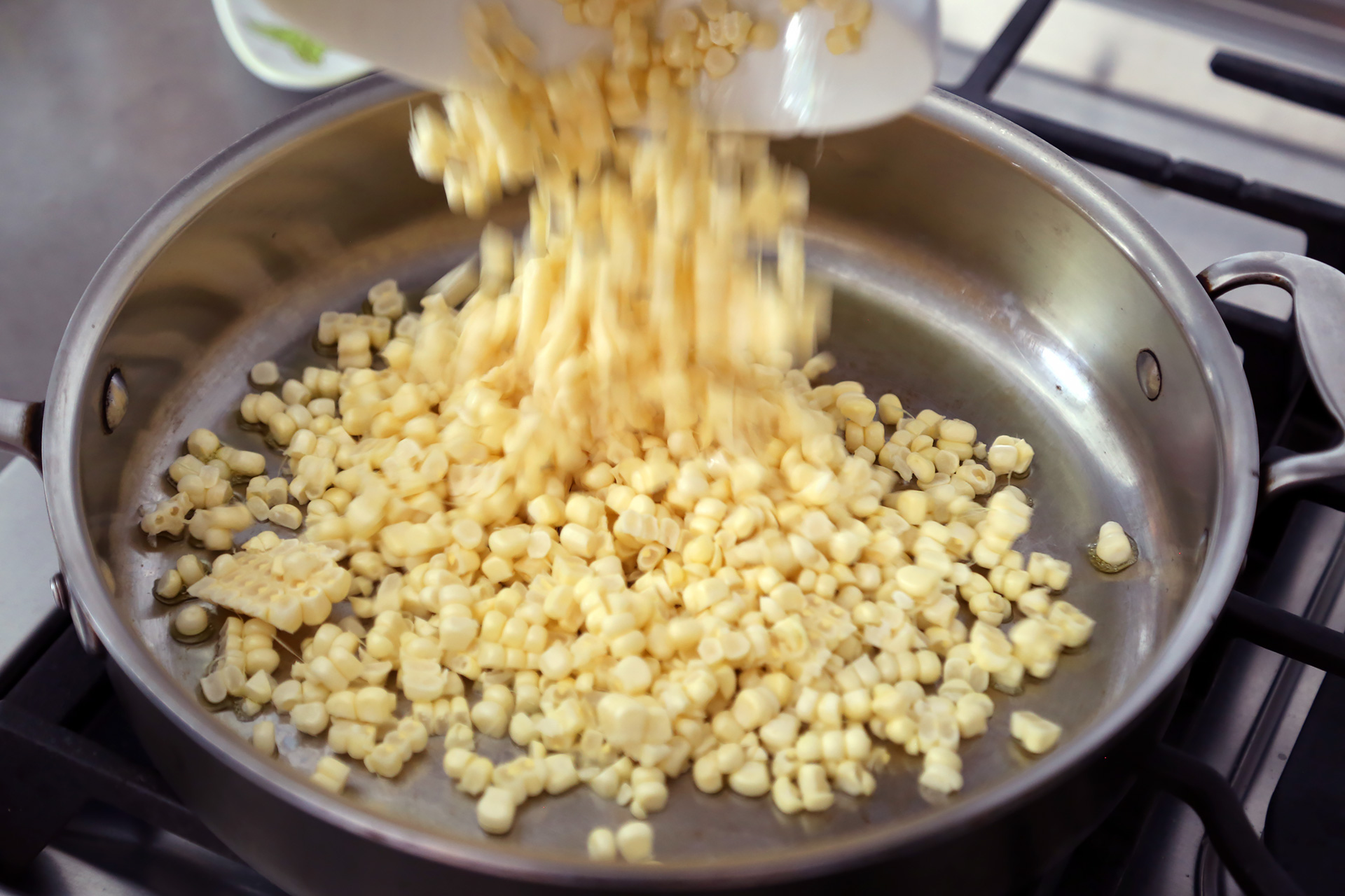 In a large frying pan over medium heat, warm the oil. Add the corn.