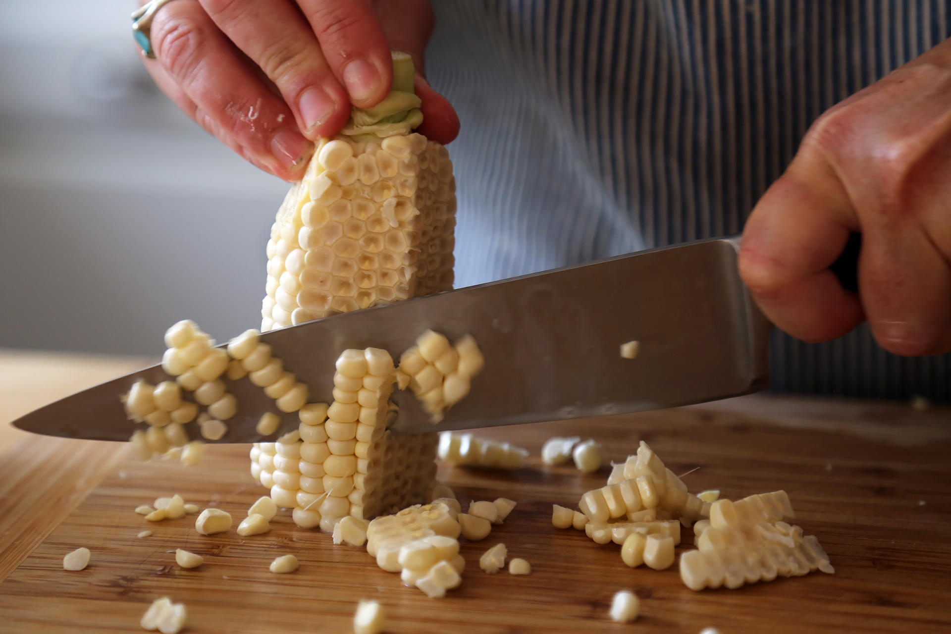 Stand the cob on the flat end, and, using a sharp knife, cut down the side of the cob to remove the kernels.
