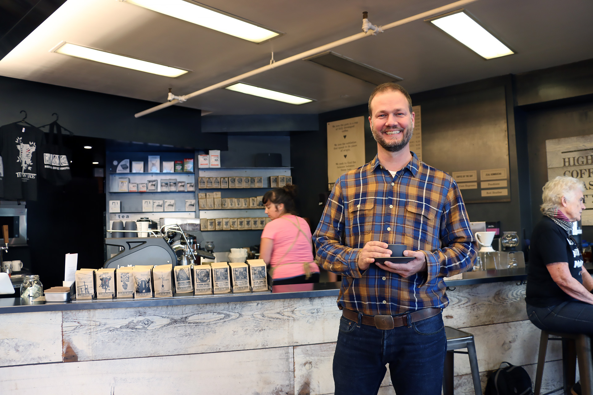 Highwire co-owner Robert Myers enjoys a cup in front of his café’s current selections.