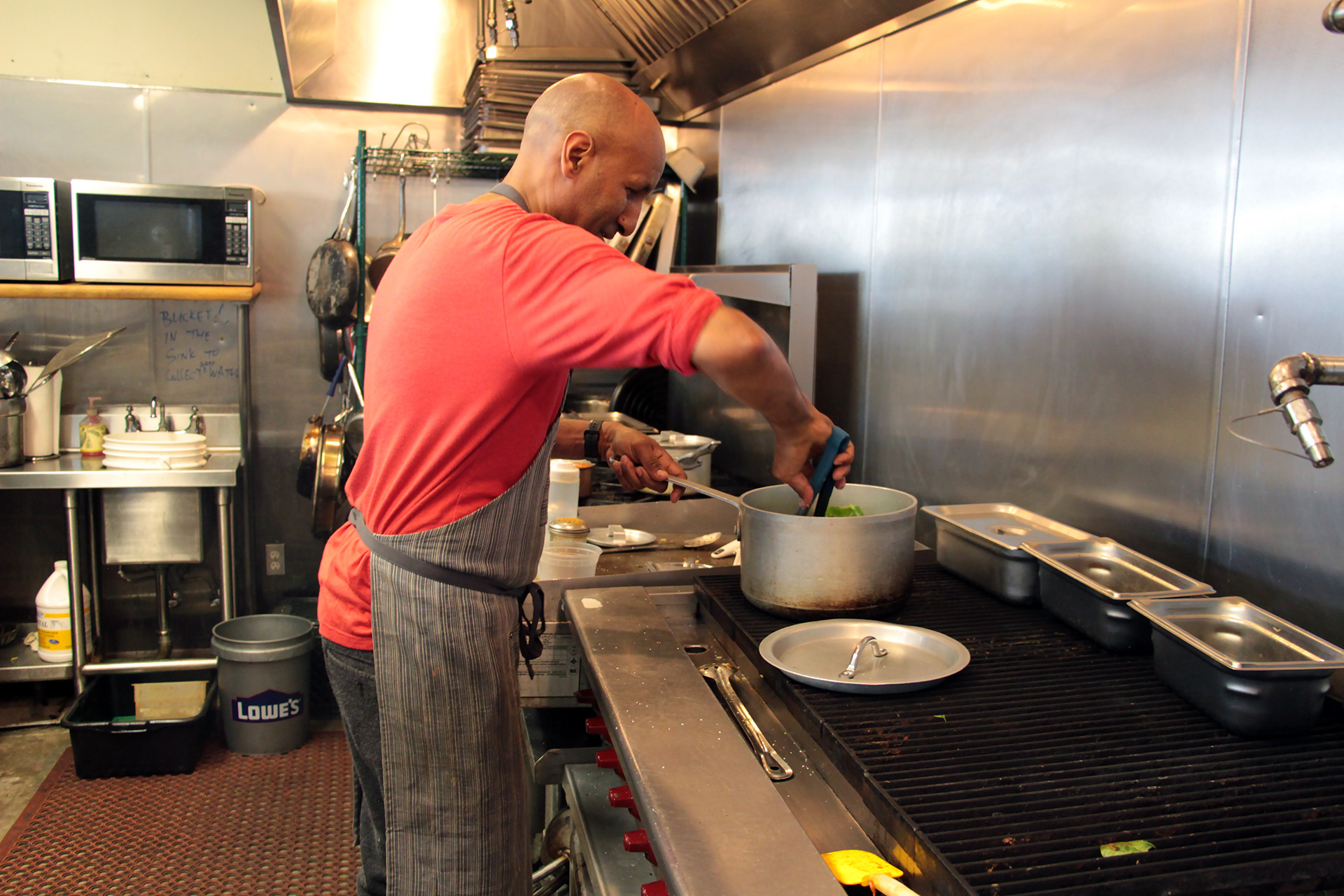 Eskender Aseged, owner/chef at Radio Africa, cooking in the kitchen.