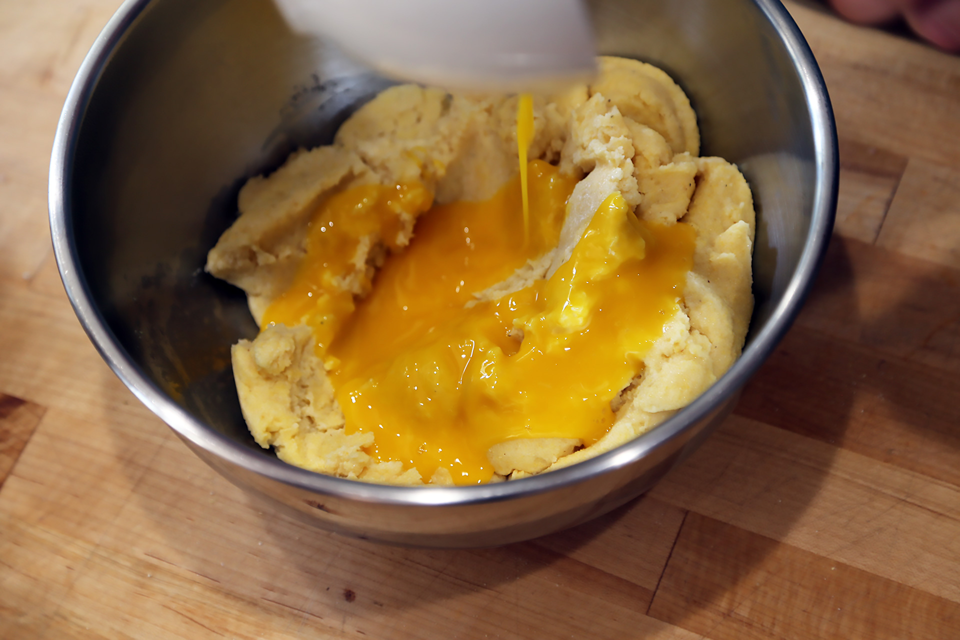 Drizzle the egg yolks over the warm cornmeal mixture, stirring quickly and constantly with a rubber spatula. 