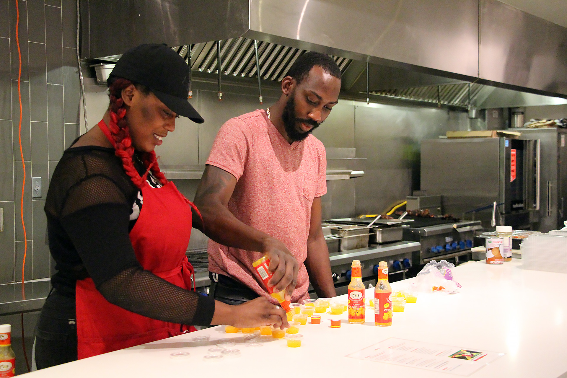 Co-owner and Chef OB Matterson (R) and staff filling containers with Scotch Bonnet Pepper Sauce.