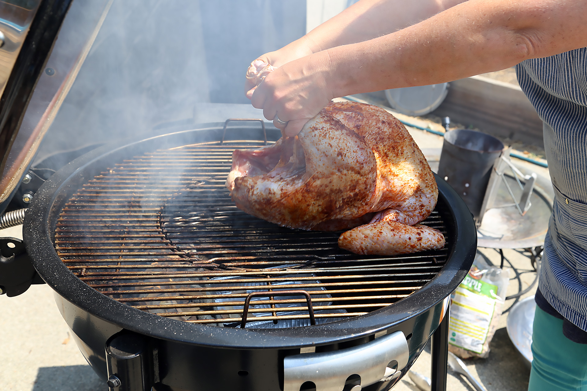 osition the cooking grate in place, then place the turkey over the drip pan with the legs facing toward the coals.