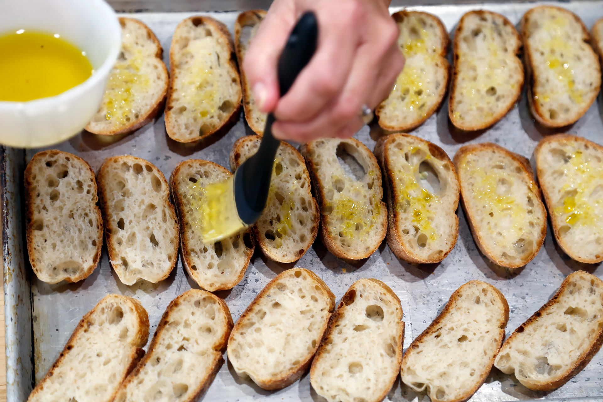 Brush the baguette slices with the olive oil, place the bread in a single layer on a baking sheet.