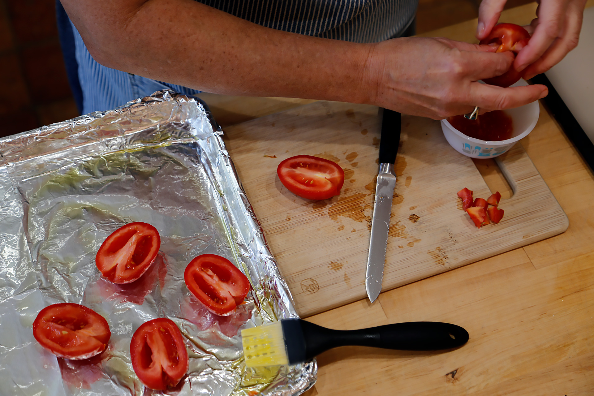 Cut the tomatoes in half lengthwise, trim away the stem end, and gently squeeze out the seeds.