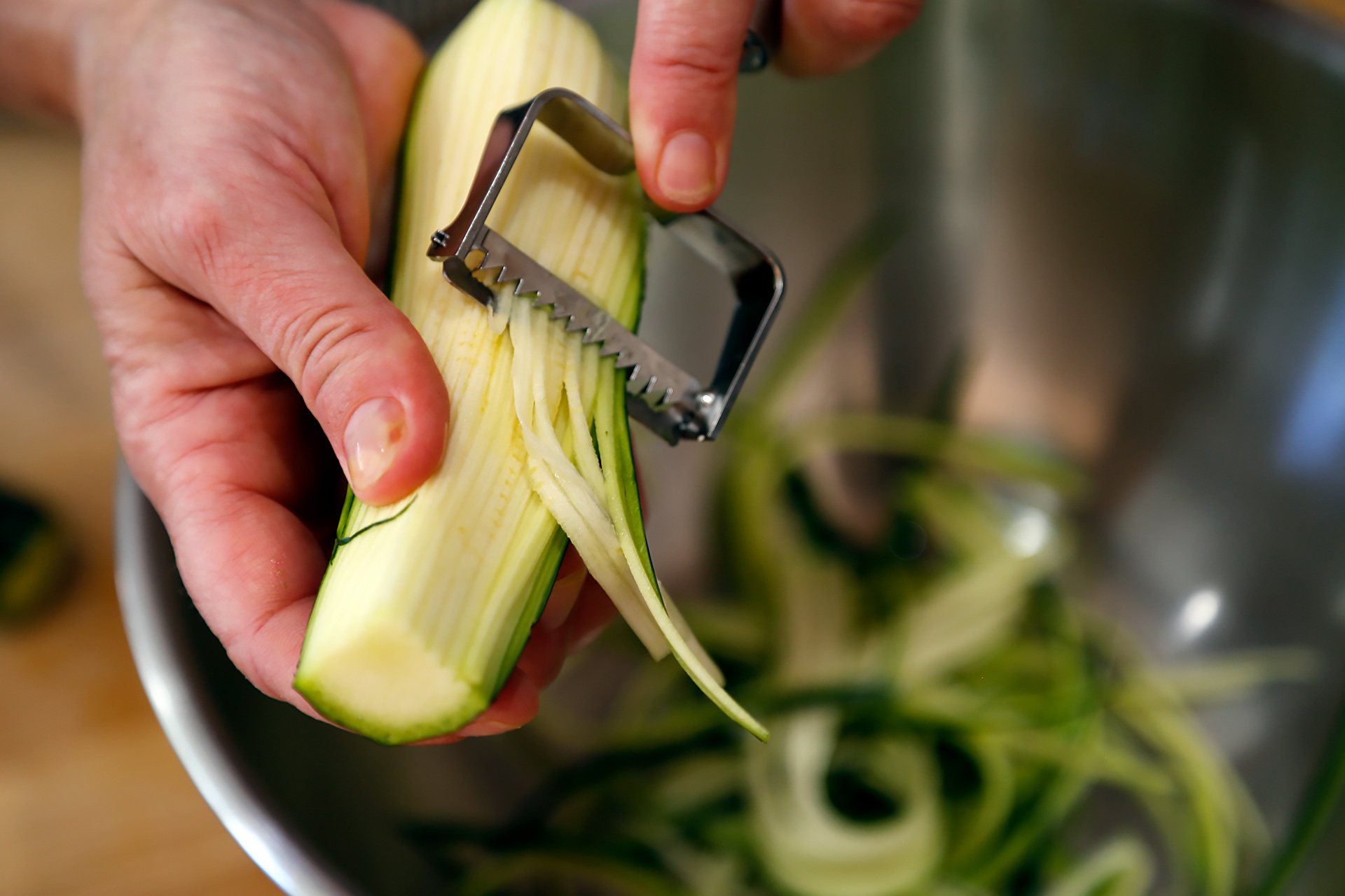 Use a spiral vegetable cutter to cut the zucchini into “noodles.”