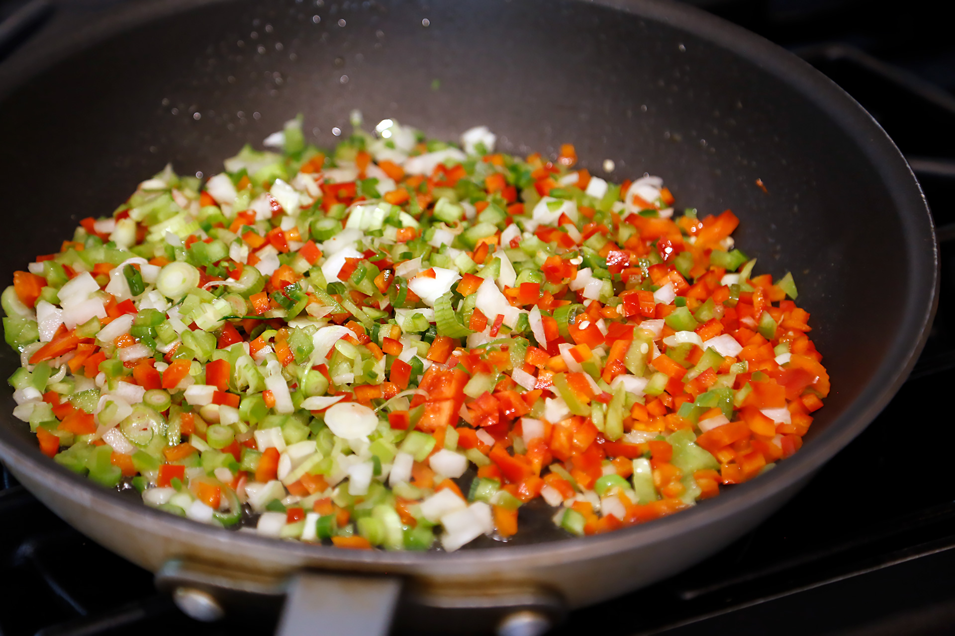In a large skillet over medium-high heat, heat the oil. Add the onions, peppers, and jalapeño chile and cook, stirring until vegetables are soft but still have some crunch and integrity, add garlic to soften with other vegetables and cook about 10 minutes.