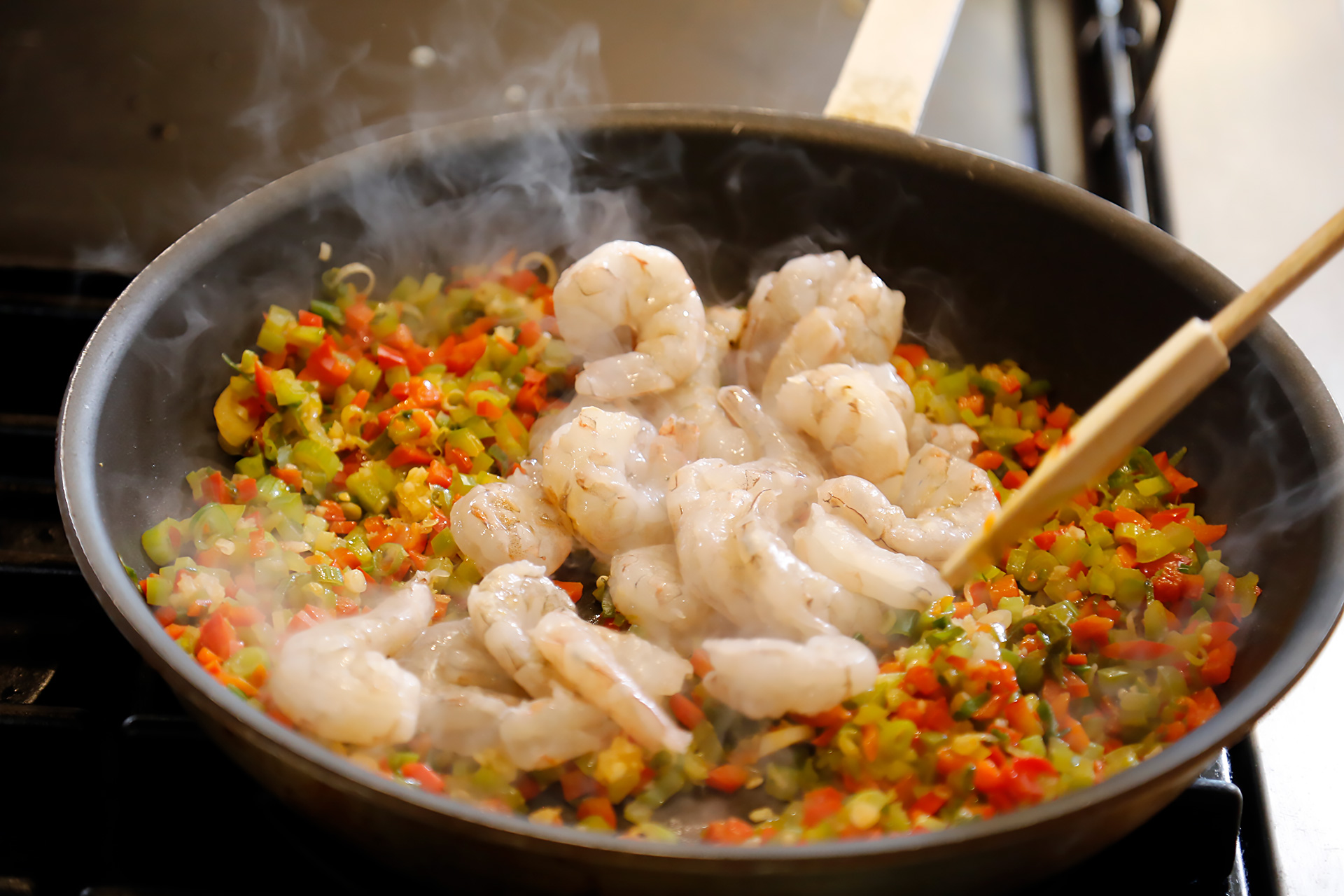 Add shrimp, sprinkle with Creole spice and sear on one side.