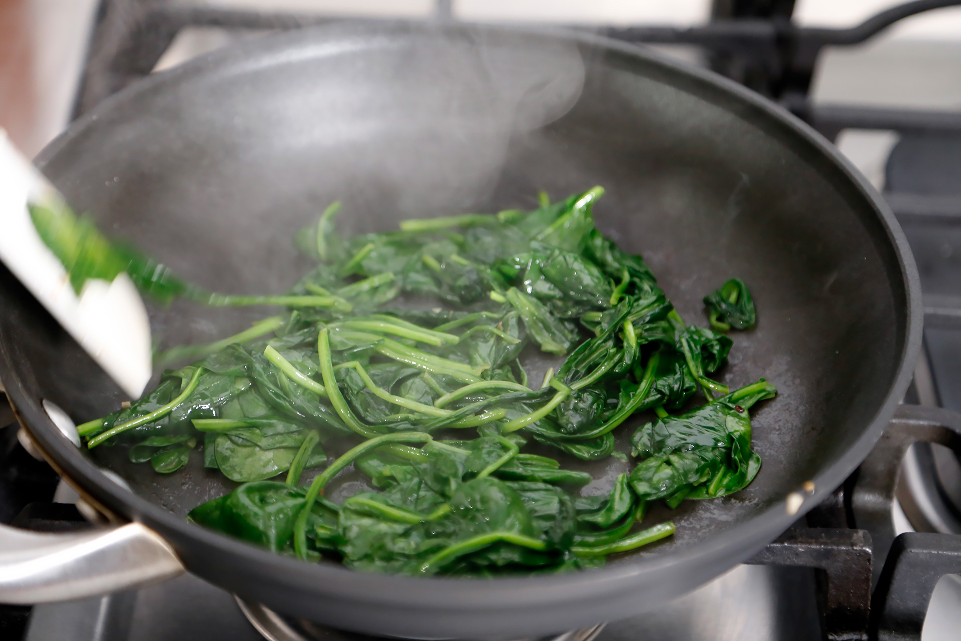 Add the spinach. Cook just until wilted, then transfer to a colander.