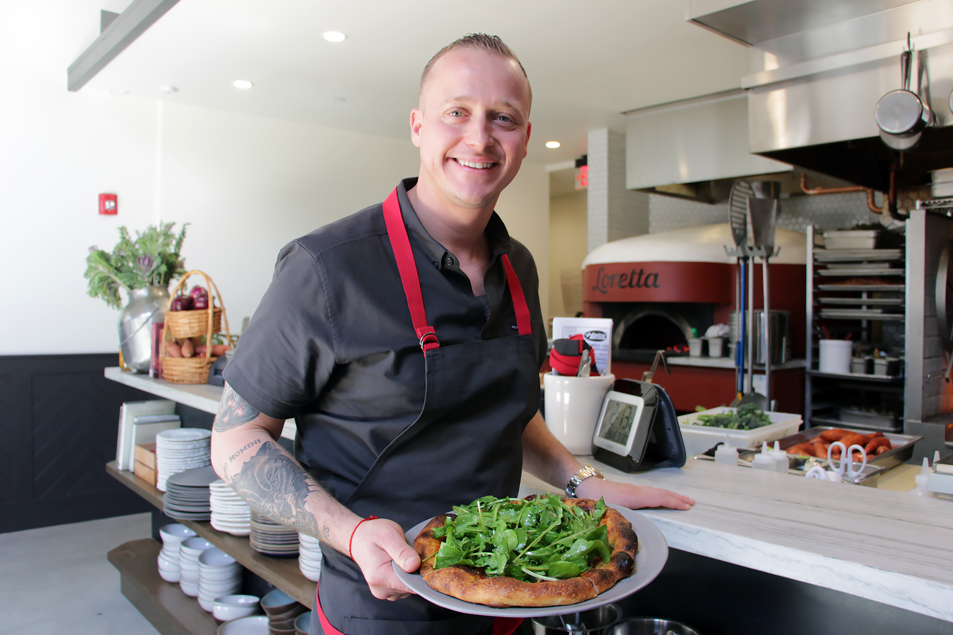 Chef/Co-Owner David Nayfeld holding Marinara, Anchovy, Arugula Pizze at Che Fico