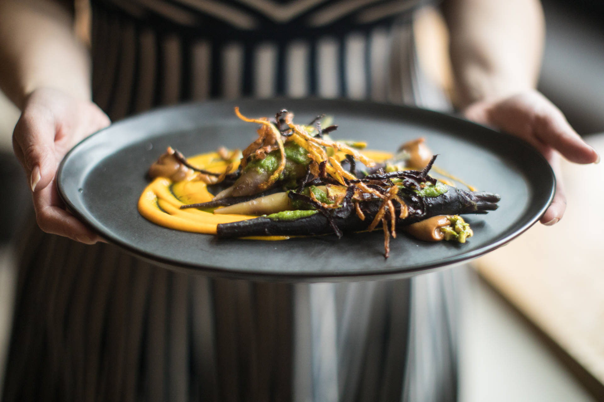 "This dish is every form of carrot you can use," Ma says. It features blanched, sauteed heirloom carrots topped with fried, crunchy strips of carrot skin with a side of pesto made with pureed carrots and the green carrot tops that are usually discarded.