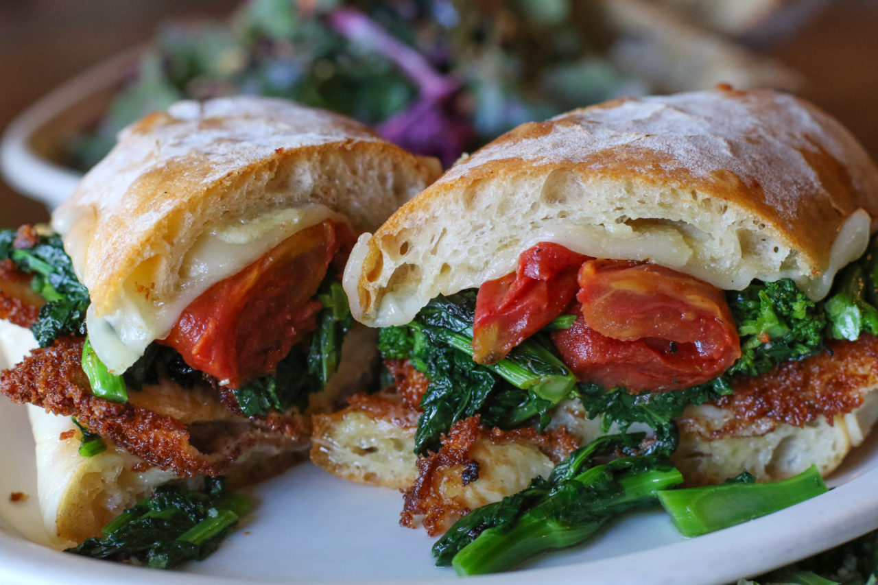 Philly sandwich with fried chicken breast, provolone, oven roasted tomatoes and broccoli rabe.