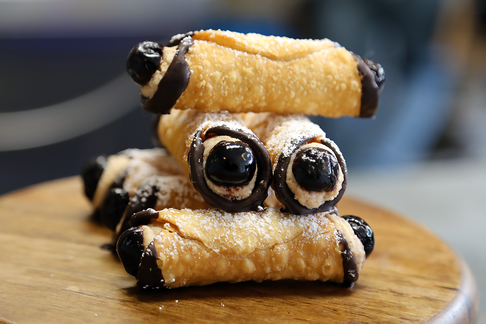 Chocolate-drizzled cannolis with Luxardo cherries dramatically peeking out of both ends.