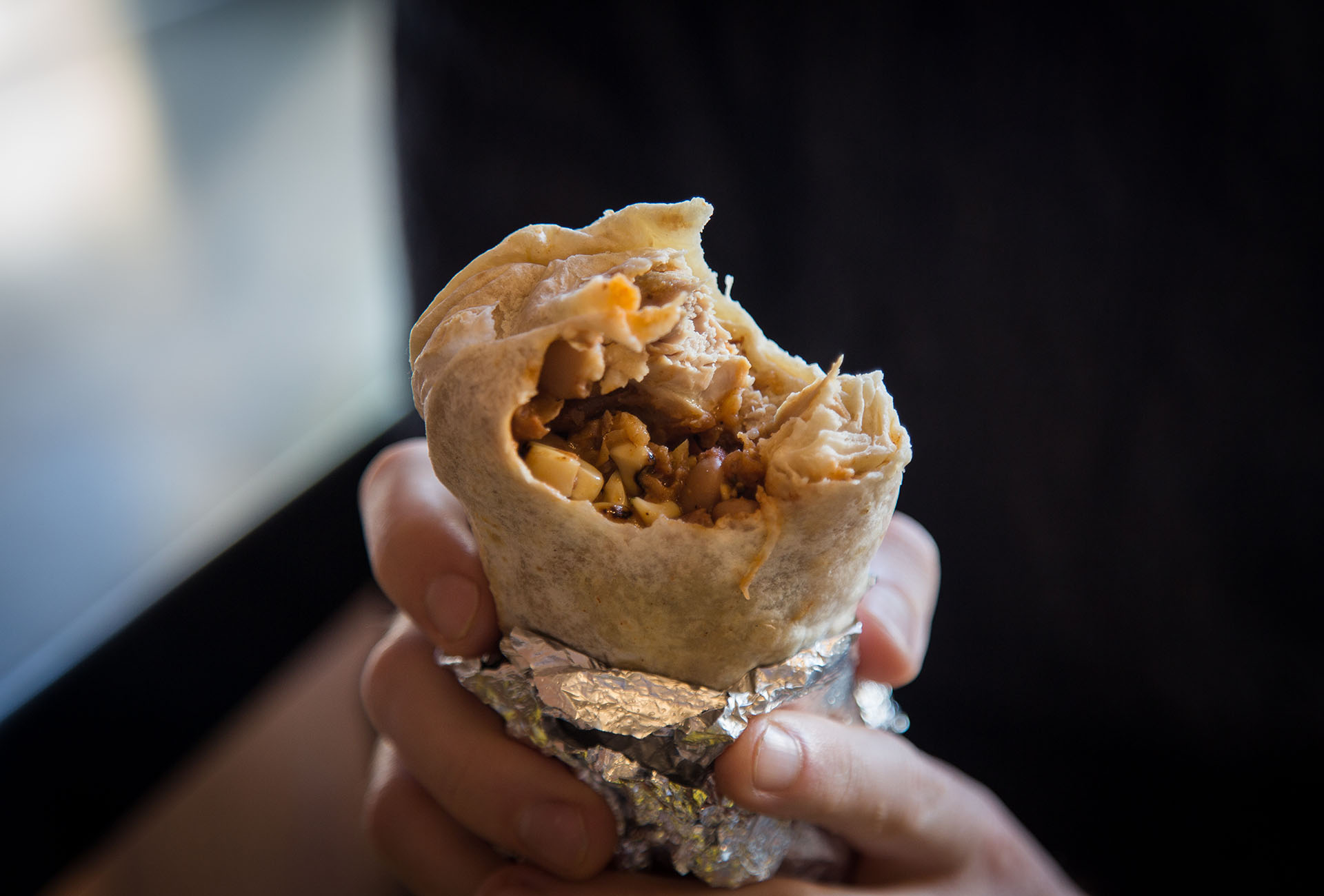 The inside of the Fried Chicken Burrito, and a glimpse of a crispy piece of Fried Chicken inside.