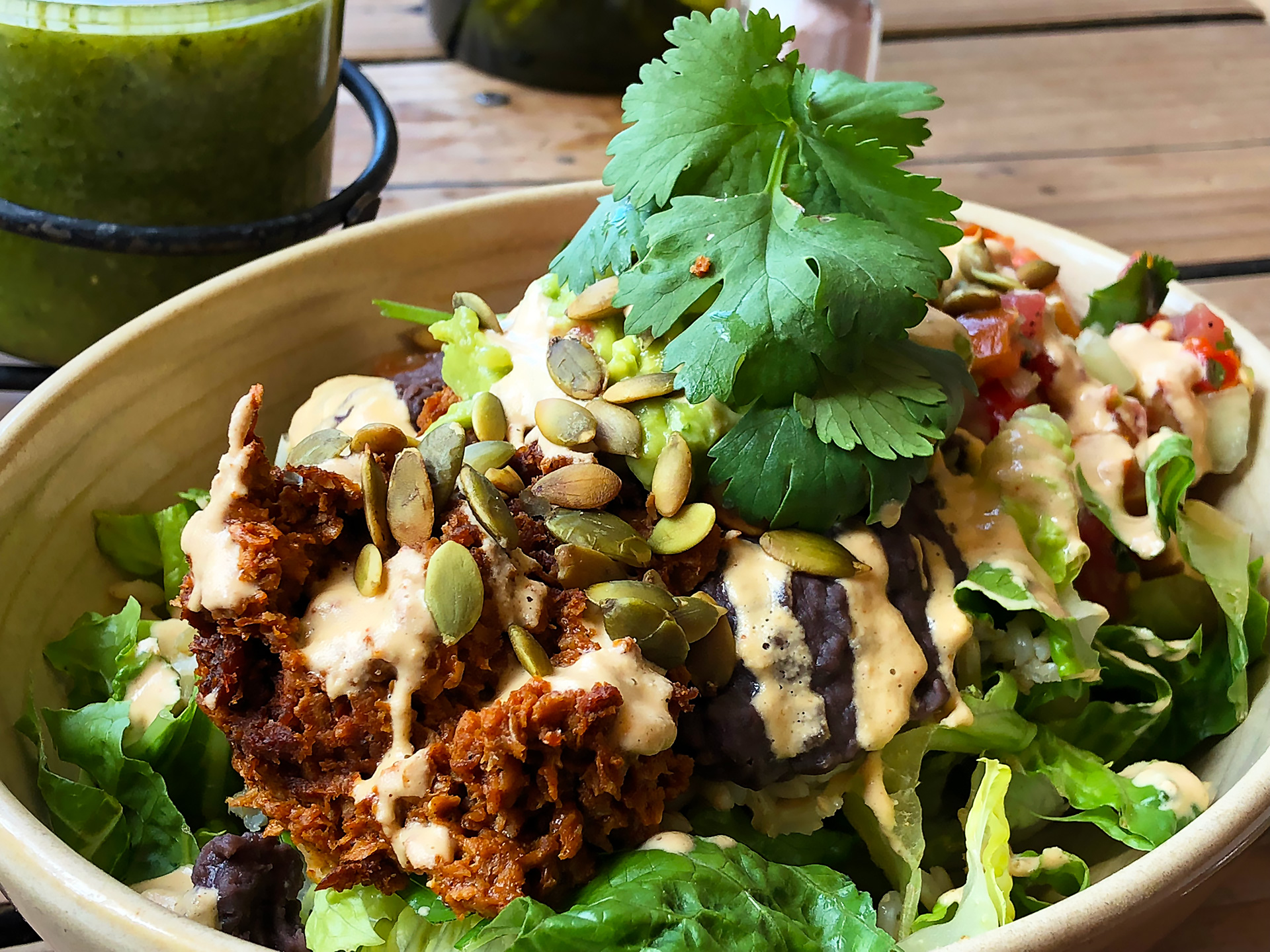 Bowl Uno: Tempeh chorizo, black beans, guacamole, brown rice and pico de gallo served on a bed of romaine and topped with nacho cashew cheese and pepitas. ($15)