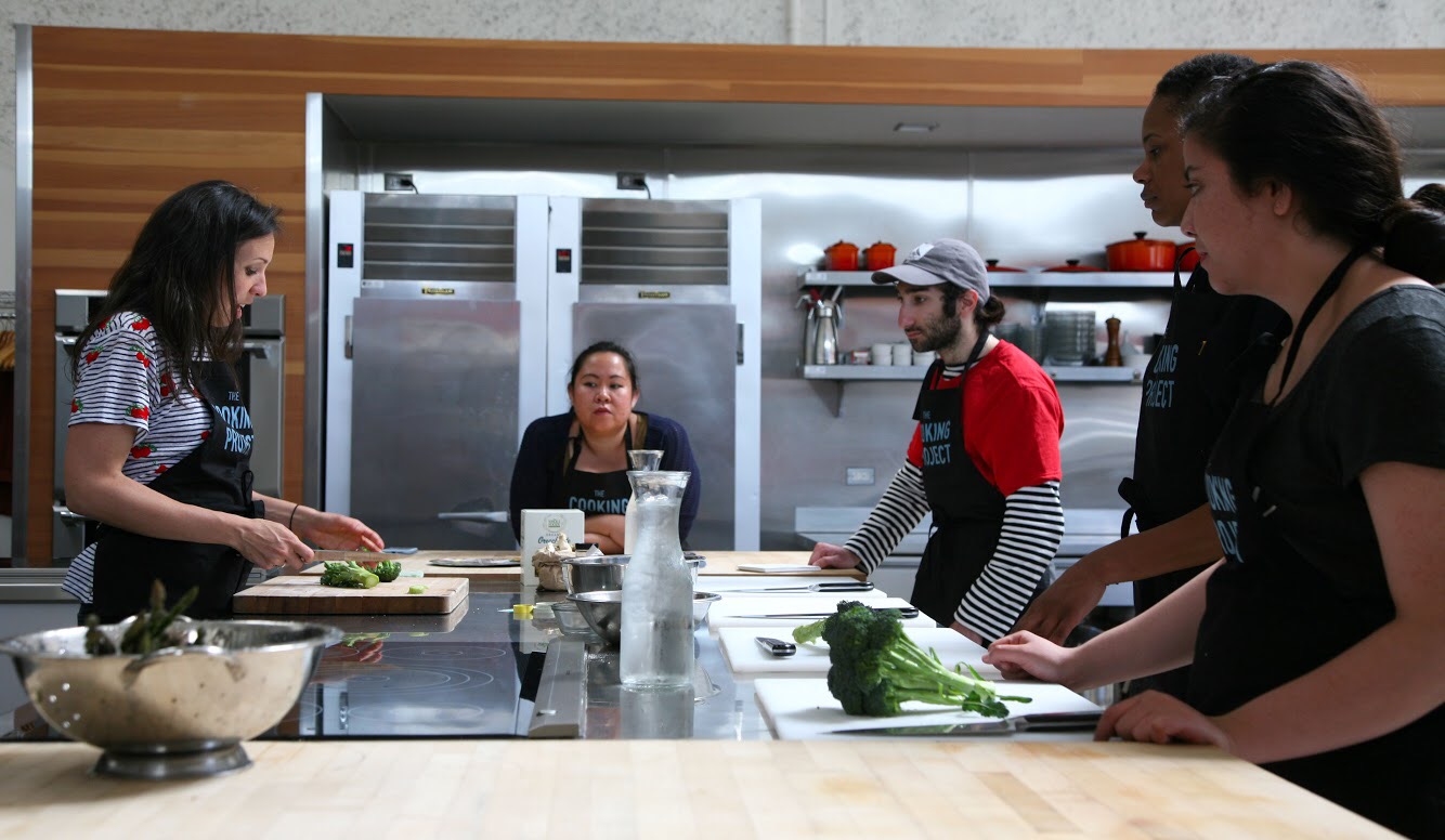 Students from the University of San Francisco's Guardian Scholars Program and members of The Cooking Project prepare a broccoli pasta dish.