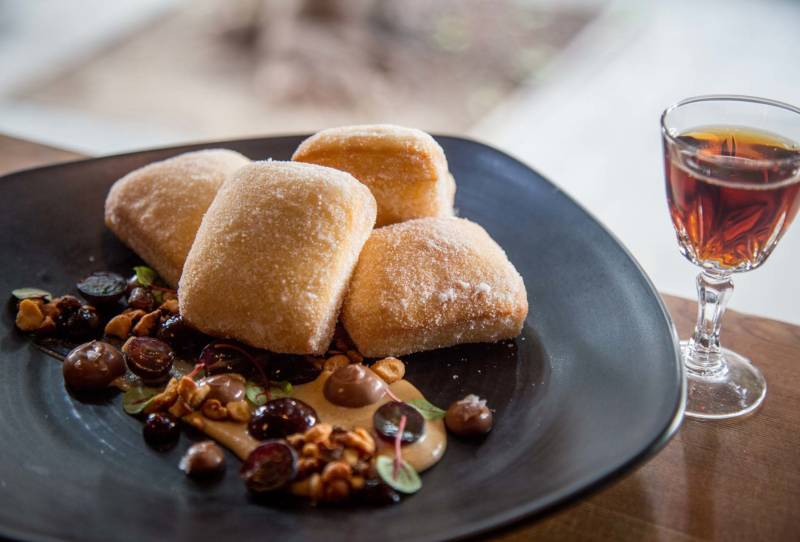 The classic PB&J sandwich is reimagined as fluffy beignets with a peanut butter sauce with concord grapes.