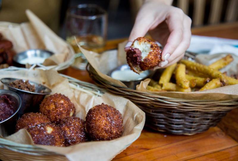 The Parmesan and Rosemary Mashed Potato Tots come with two condiment options: bacon jam and cranberry-walnut jam.