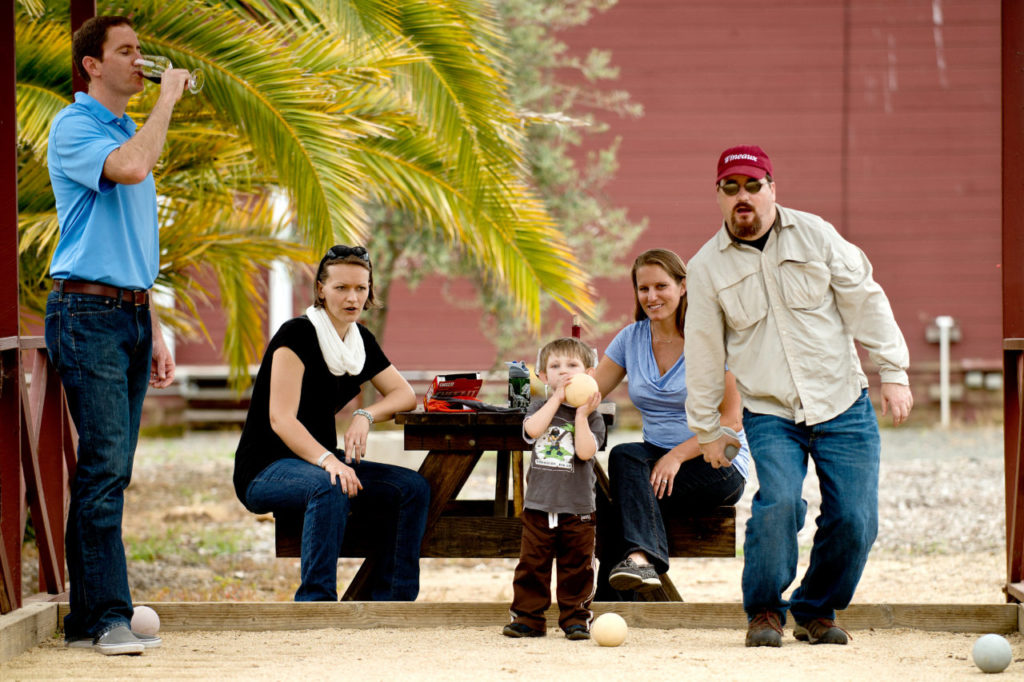 Jay McCarthy, right, lines up his next throw with his three-year-old son, Eddie, while Kira Plaine, Monika McCarthy and Dan Plaine look on, at the bocce ball court outside Kokomo Winery in Healdsburg, Calif., on April 6, 2013.