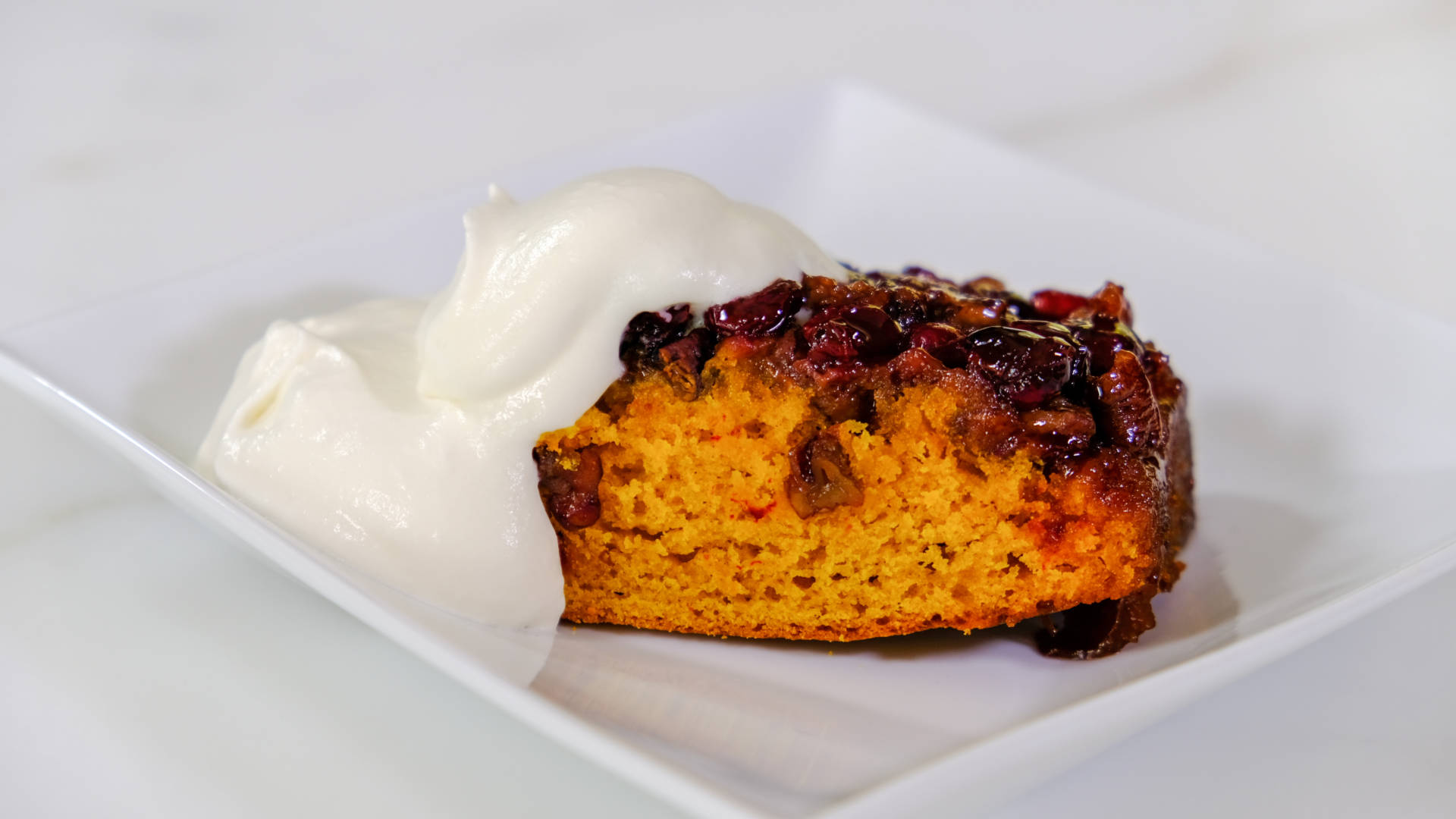 Emily Luchetti's Pumpkin Upside-Down Cake topped with fresh whipped cream.