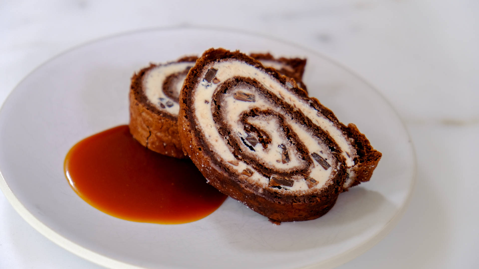 Chocolate roulade filled with chocolate chip ice cream and topped with the best caramel sauce.