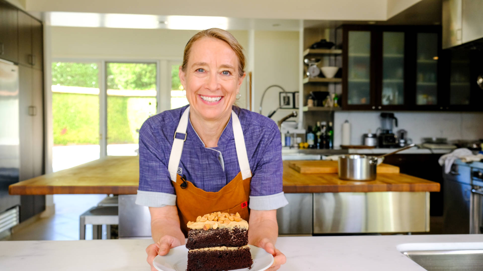 Chef Emily Luchetti with a slice of her classic chocolate cake topped with peanut butter frosting and honeyed peanuts.
