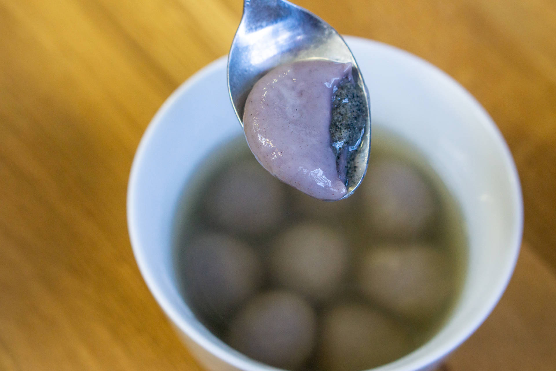 Black sesame tang yuan served in a cane sugar syrup.