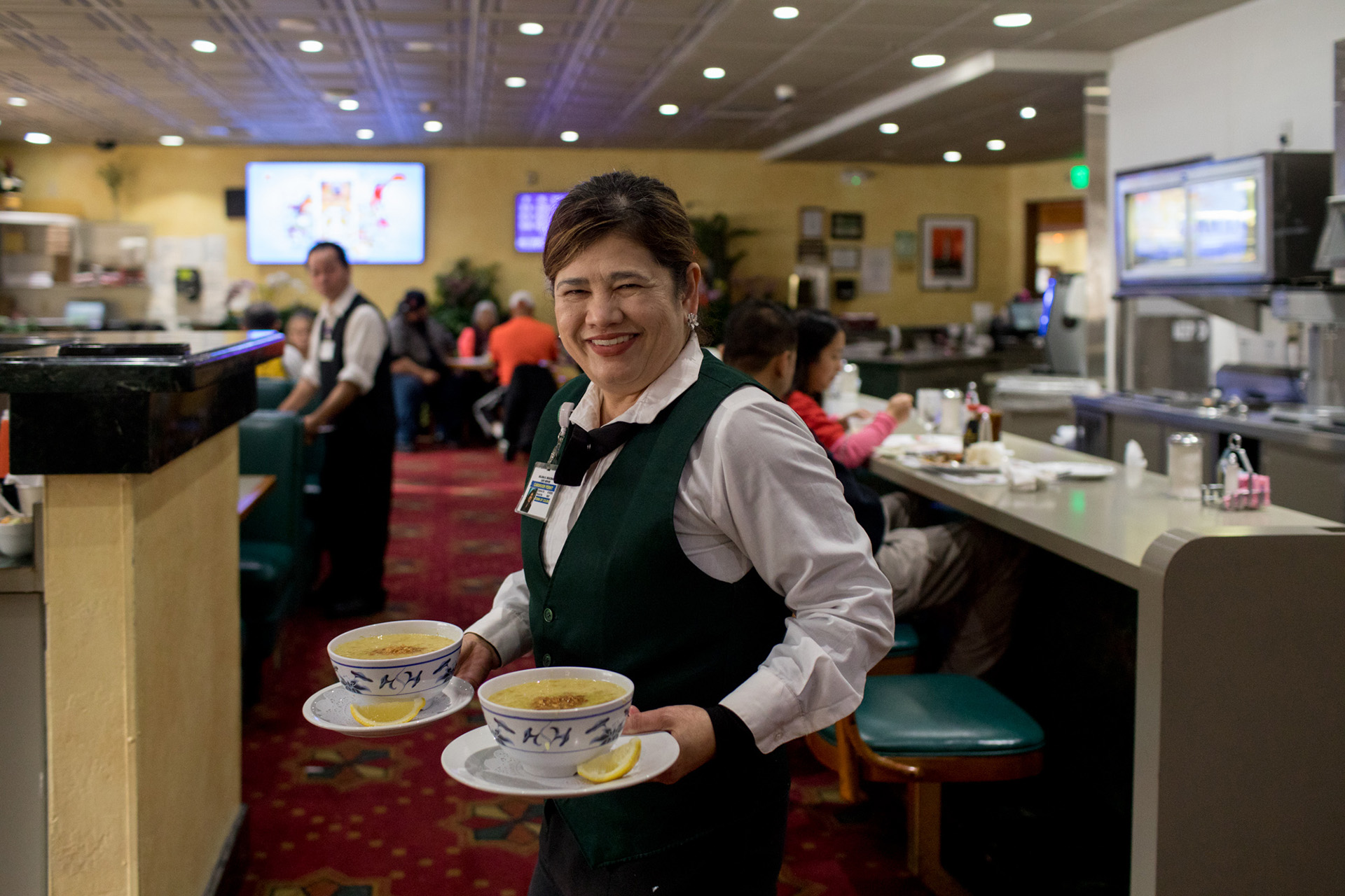 Lucky Chances casino has an all-ages cafe that serves Filipino classics along with American diner staples. Server Melissa Deguzman carries goto (beef tripe and garlic rice porridge) to customers.