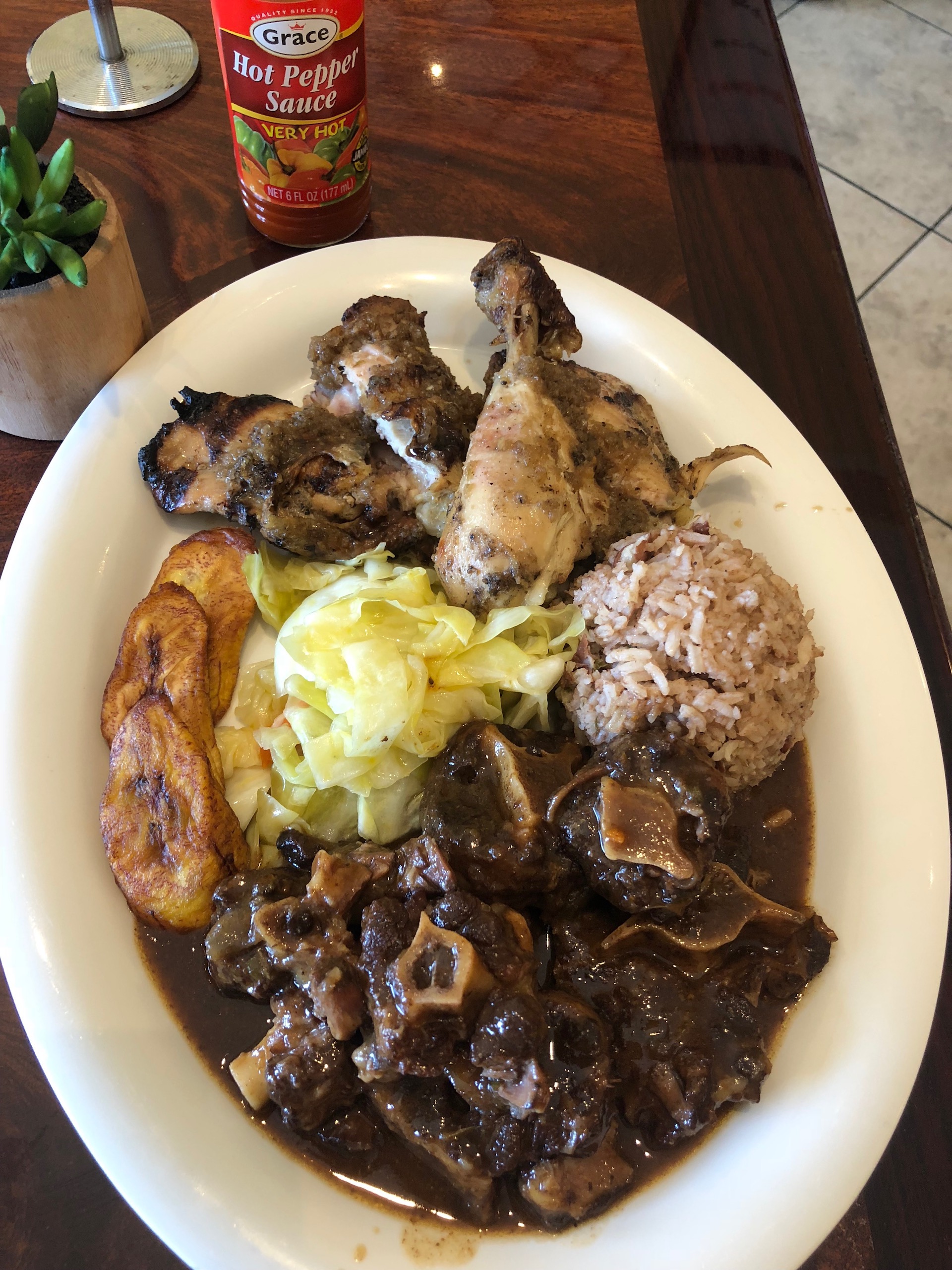 A jerk chicken and oxtail combo with plantains and rice & beans at Flavas Jamaican Grill.