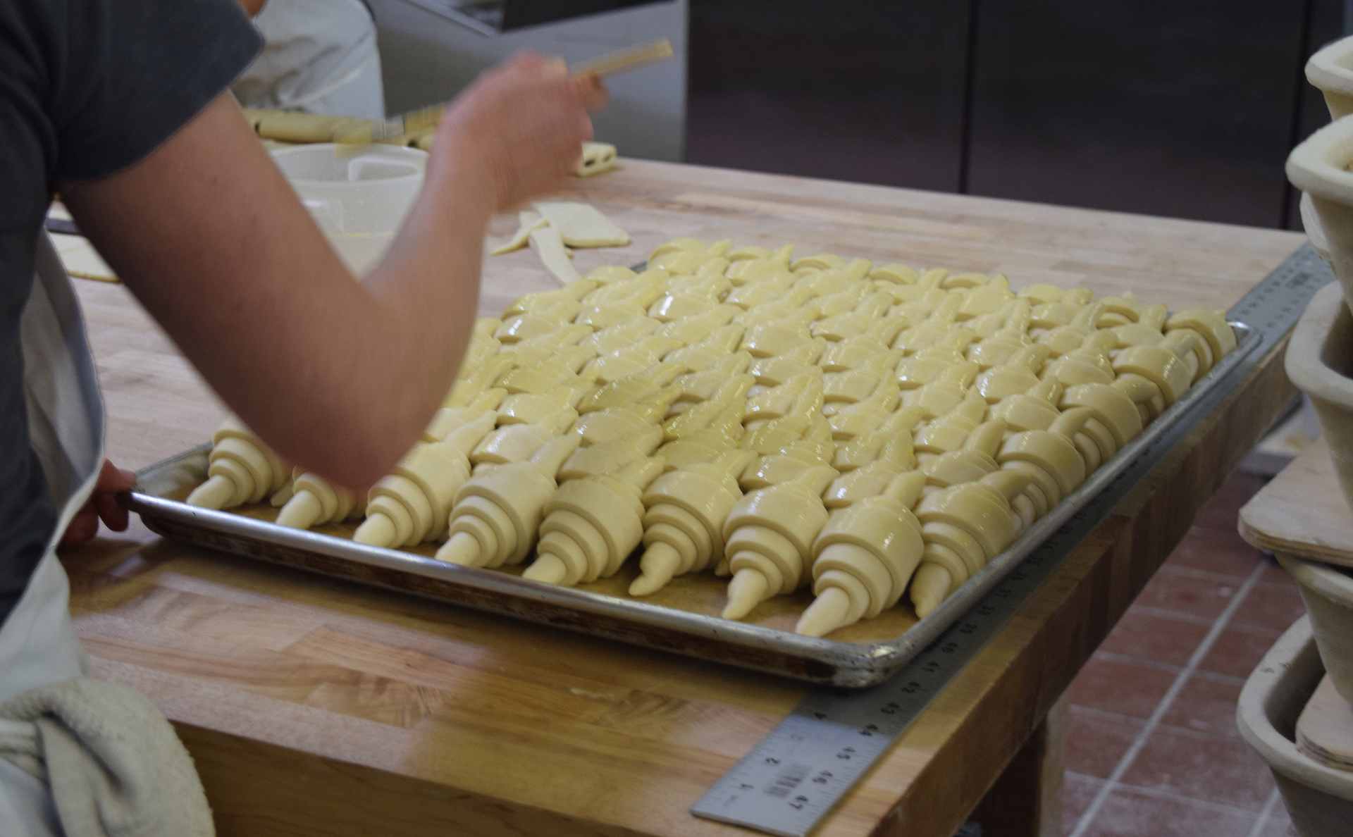 Picture-perfect croissants are buttered before baking. About 70% of bakery revenues currently come from pastries.