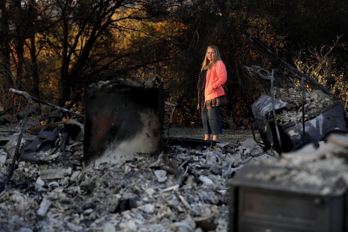 Meghan Dixon stands next to the ruins of her rental home on Hwy 128 in Healdsburg after it burned in the Kincade fire. Photo taken on Monday, November 4, 2019.