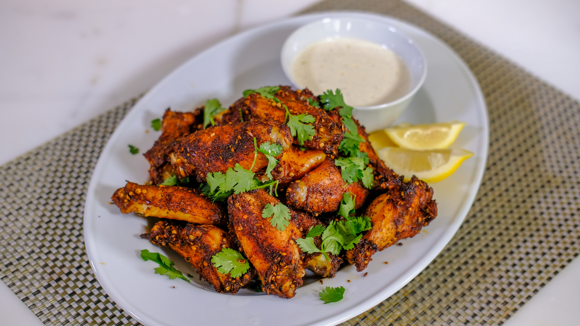 Dry rubbed Harissa Wings paired with lemon and Alabama White BBQ Sauce