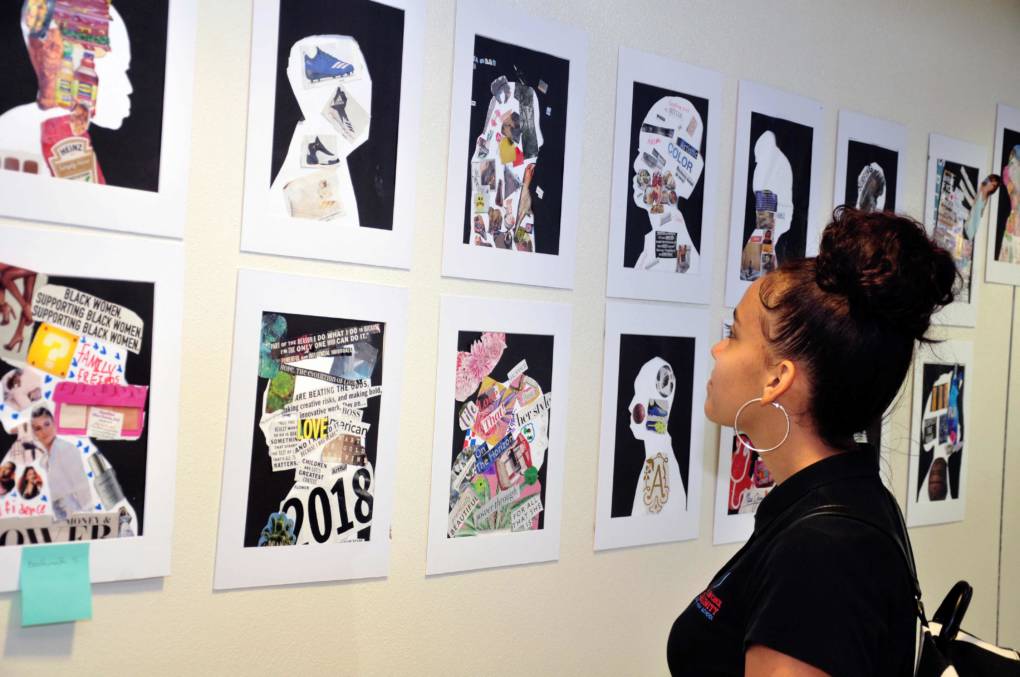 A family member looks at the gallery of student portraits portrayed on "graduation day" of Summer Bridge.