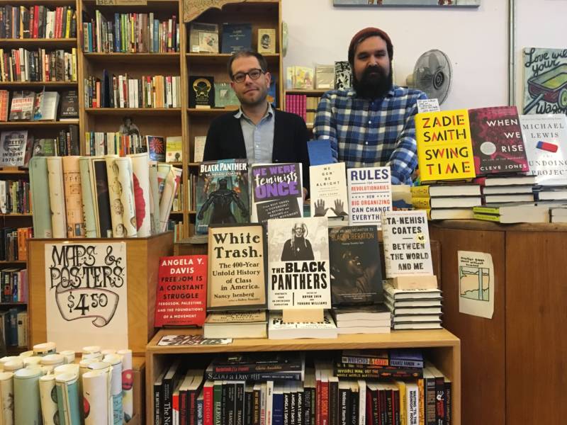 Store manager Ryan Smith (left) and Dan Weiss (right) in front of the book section Weiss created in response to Donald Trump's election.