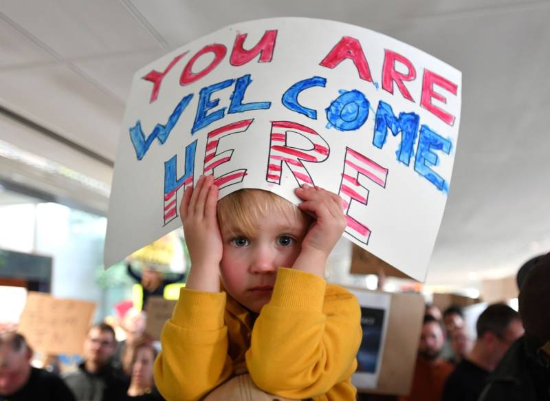 Hattie Burke-foreuic holds up a sign on her father's shoulders during a protest at San Francisco International Airport January 29, 2017 U.S. President Donald Trump issued an executive order yesterday barring citizens of seven Muslim-majority countries from entering the United States for the next 90 days and suspends the admission of all refugees for 120 days.