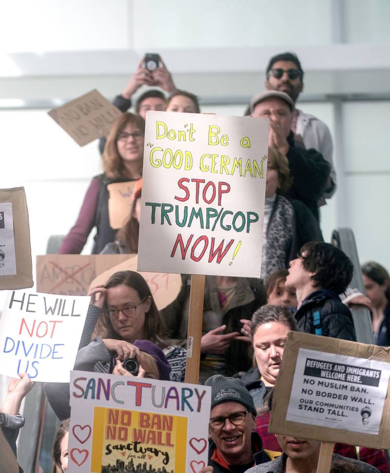 Protesters hold signs up during a protest at San Francisco International Airport in San Francisco, California on January 29, 2017. 