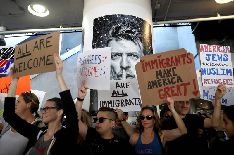 Protesters hold signs during a rally against the immigration ban imposed by U.S. President Donald Trump on January 29, 2017 at Los Angeles International Airport. 