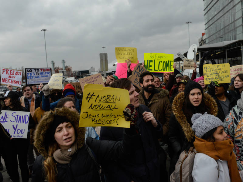 Protesters rally outside Kennedy International Airport to protest Trump's executive order on Saturday. New York City officials and immigrant advocates are holding are also holding a vigil at the airport Saturday evening.