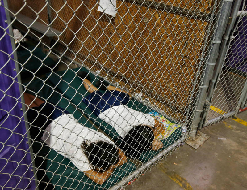 Two children sleep in a holding cell as hundreds of mostly Central American immigrant kids were being processed and held at the U.S. Customs and Border Protection Nogales Placement Center on June 18, 2014, in Nogales, Arizona.
