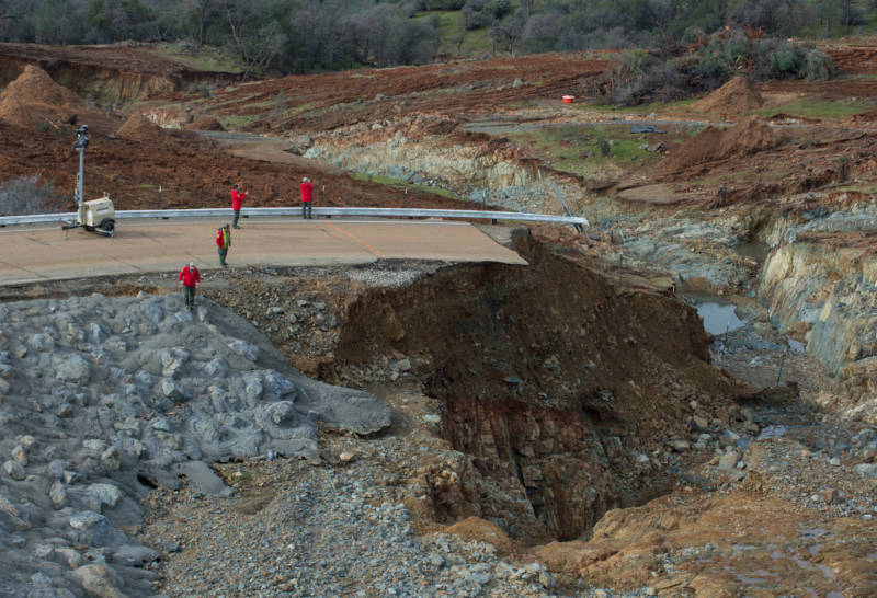 California Department of Water Resources crews inspect and evaluate the erosion just below the Lake Oroville Emergency Spillway site after lake levels receded on Monday morning. The outflow from the primary Oroville Spillway remains at 100,000 cubic feet per second (cfs) to decrease the lake level by 50 feet to handle the next round of storms this week. Photo taken February 13, 2017. 
