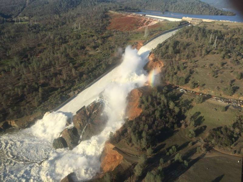 The damaged main Oroville Dam spillway next to the resultant severely eroded hillside.