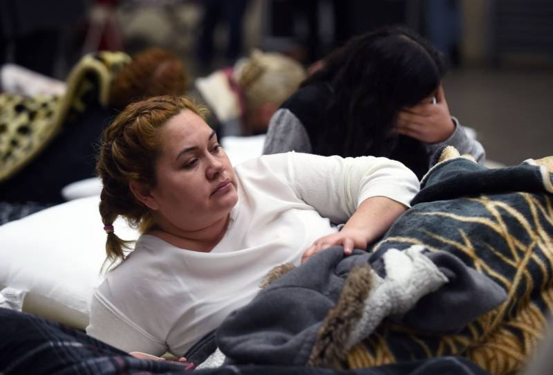 Evacuee Karina Garcia (L) looks on at the Placer County Fairgrounds evacuation center in Roseville, California on February 13, 2017. Almost 200,000 people were under evacuation orders in northern California Monday after a threat of catastrophic failure at the United States' tallest dam. Officials said the threat had subsided for the moment as water levels at the Oroville Dam, 75 miles (120 kilometers) north of Sacramento, have eased. But people were still being told to stay out of the area. 