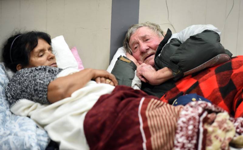 Evacuees Steve Allen (R) and Alicia Castro (L) lay on a cot at the Placer County Fairgrounds evacuation center in Roseville, California on February 13, 2017. Almost 200,000 people were under evacuation orders in northern California Monday after a threat of catastrophic failure at the United States' tallest dam. Officials said the threat had subsided for the moment as water levels at the Oroville Dam, 75 miles (120 kilometers) north of Sacramento, have eased. But people were still being told to stay out of the area.