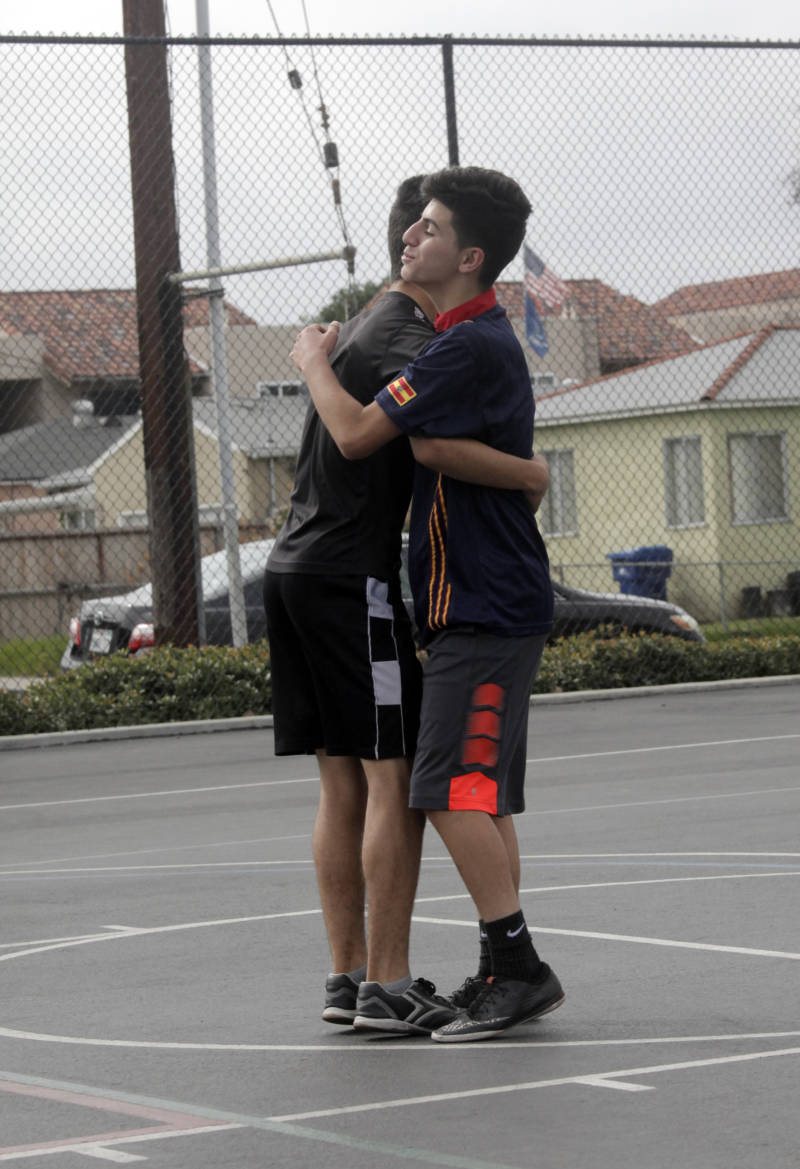 Osama Abdulazeez (right) hugs teammate Dani Matti during a pick-up soccer game.