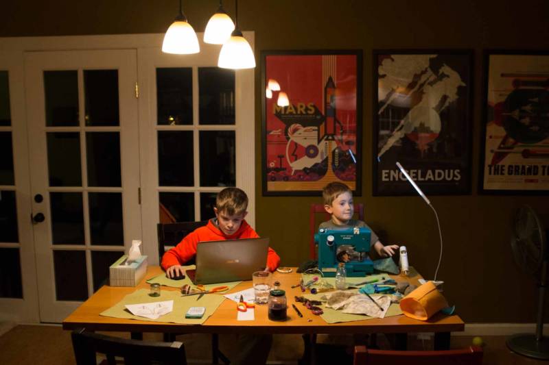 Ryan and Nicolas Halstead work on their homework after school in Napa, CA. Ryan is sewing, while his brother is learning to code.
