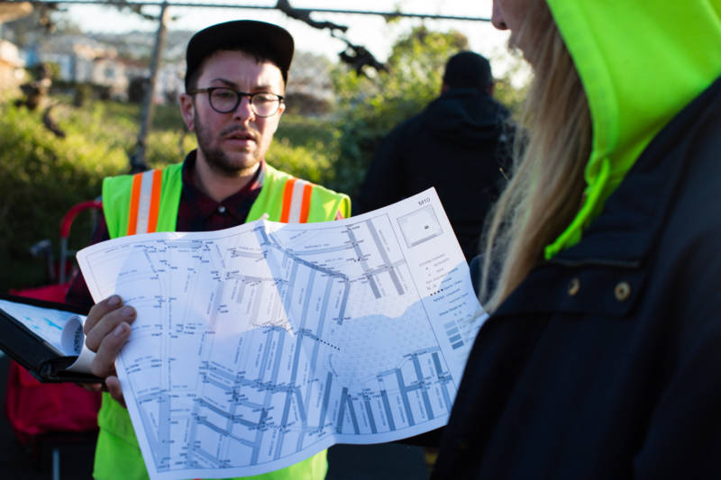 Lorae Fernandis (left) briefs Kevin Lash (right) on his route for mosquito abatement in San Francisco on the morning of March 23, 2017. They and other members of the Mosquito Abatement Courier (MAC) crew distribute larvicide tablets throughout the city's storm drains by bicycle.