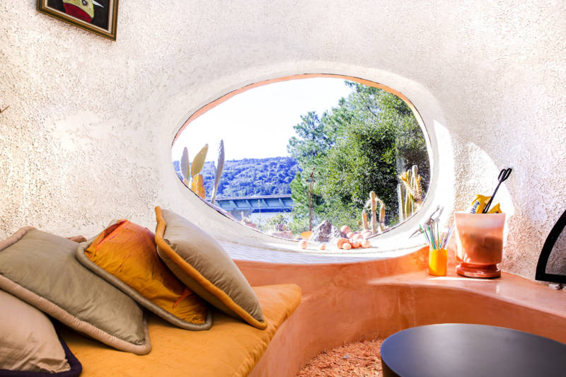 Inside the dome, in the “conversation pit,”, there’s tons of natural light, and a great view of the Crystal Springs Reservoir out of the window – which is shaped, as many of the windows in this home are, like an amoeba. Everything accentuates the biomorphic quality of the place. 